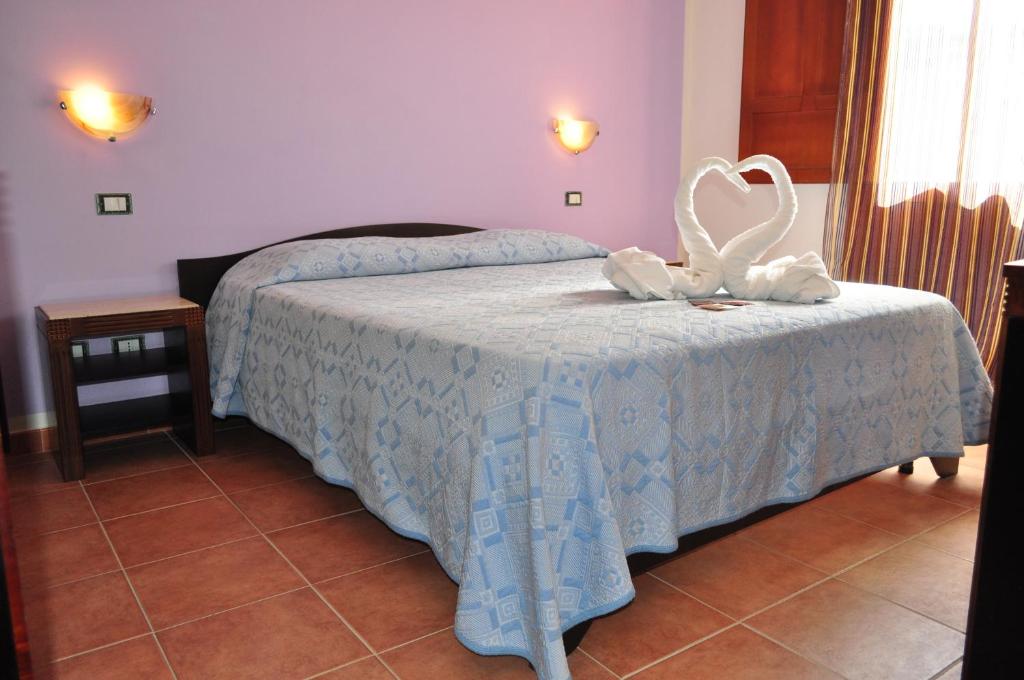 a bedroom with a bed with a swan decoration on it at Bed & Breakfast Adriana in San Vito lo Capo