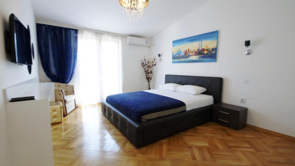1 dormitorio con cama y lámpara de araña en Apartments Miković, en Budva