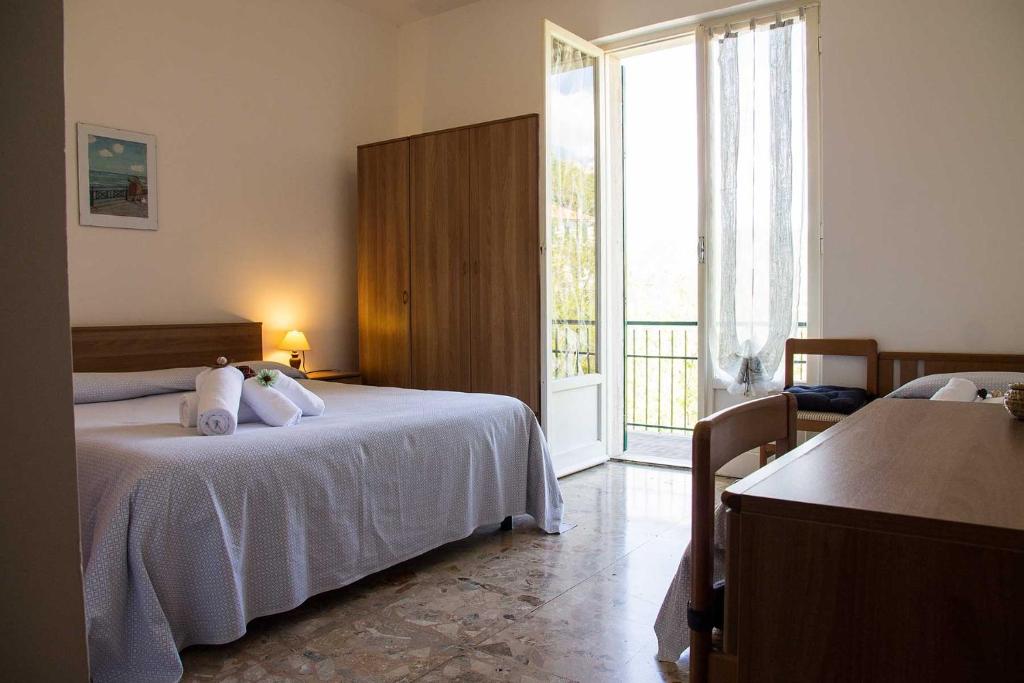 a bedroom with two beds and a large window at Hotel Silvia in Framura