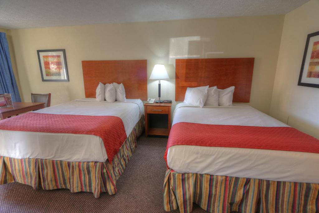 a hotel room with two beds with red and white sheets at Days Inn By Wyndham Pigeon Forge South in Pigeon Forge