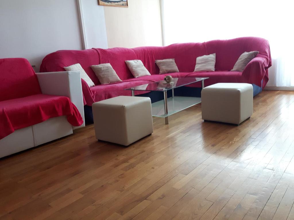 - un salon avec un canapé rouge et une table en verre dans l'établissement Apartment Trstenik, à Split