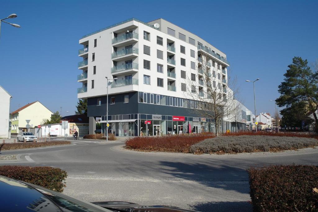 - un grand bâtiment blanc dans une rue de la ville dans l'établissement Apartmán Centroom, à Piešťany