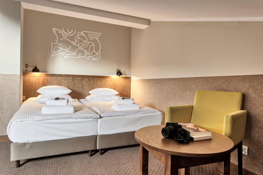 クラクフにあるDaniel Griffin Aparthotel by Artery Hotelsのベッドとテーブルが備わるホテルルームです。