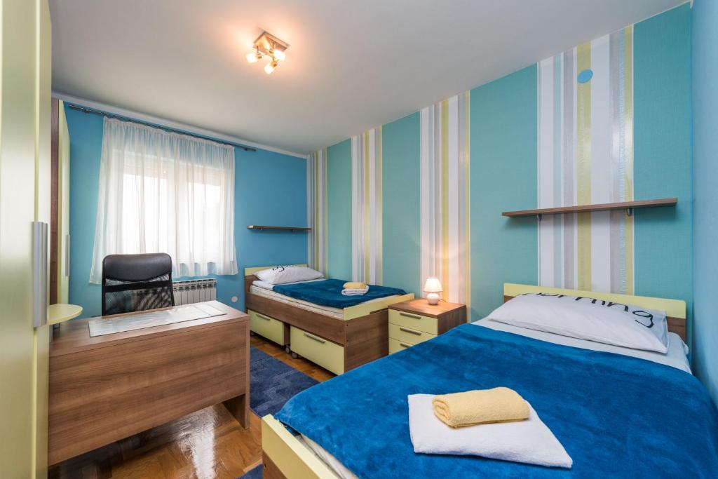 pokój z 2 łóżkami i krzesłem w obiekcie Kristina Apartments w mieście Zadar