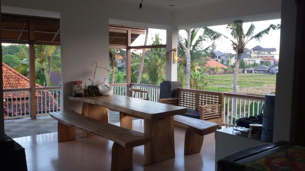 ウブドにあるブルー マンゴのバルコニー付きの客室で、木製テーブルとベンチが備わります。