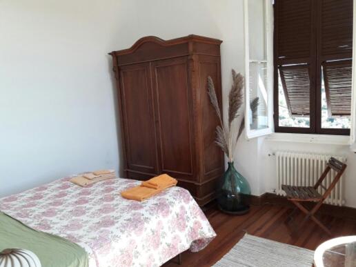 a bedroom with a bed and a cabinet and a chair at Trekking in paradise B&B in Santa Margherita Ligure