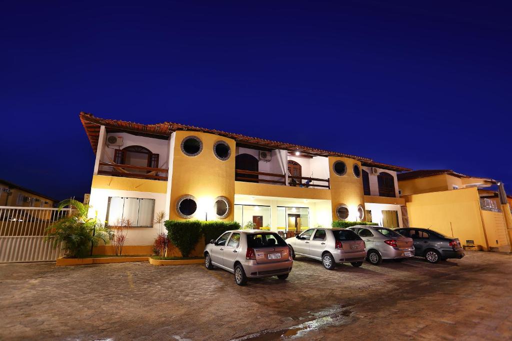 un edificio con coches estacionados en un estacionamiento en Andimar Hotel, en Porto Seguro