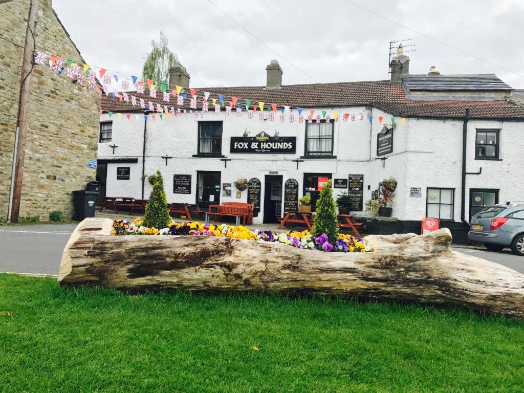 a large tree log in front of a building at The Fox & Hounds Inn in West Burton