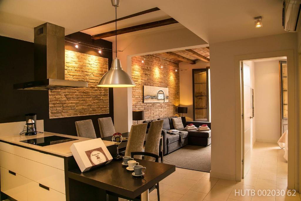 a kitchen and living room with a table and a couch at Alcam Molino in Barcelona