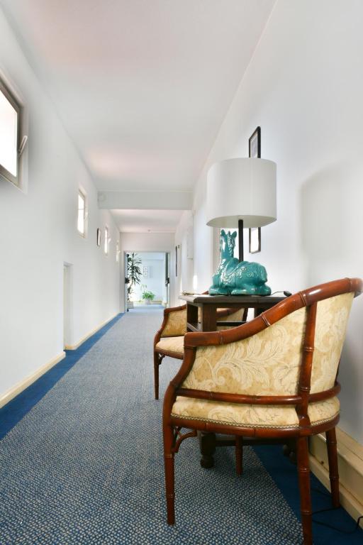 a hallway with two chairs and a lamp on a table at Carvoeiro Garden Hotel in Carvoeiro