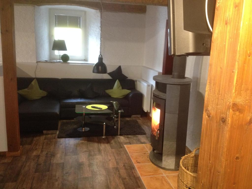 a living room with a couch and a fireplace at Die kleine Pension in Gößweinstein