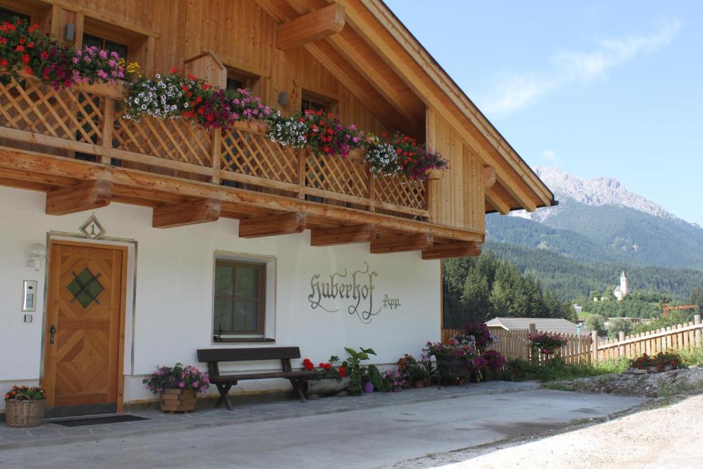 a building with a balcony with flowers on it at Huberhof in San Candido