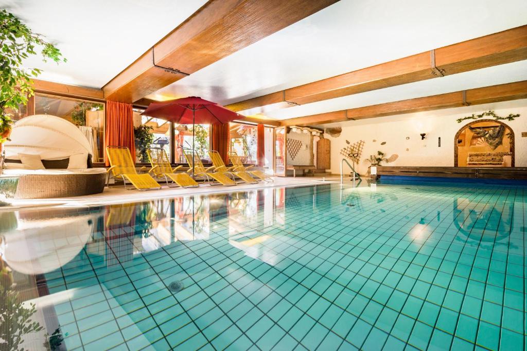 a large swimming pool with yellow chairs at Land-gut-Hotel Landgasthof Zum Schildhauer in Halfing