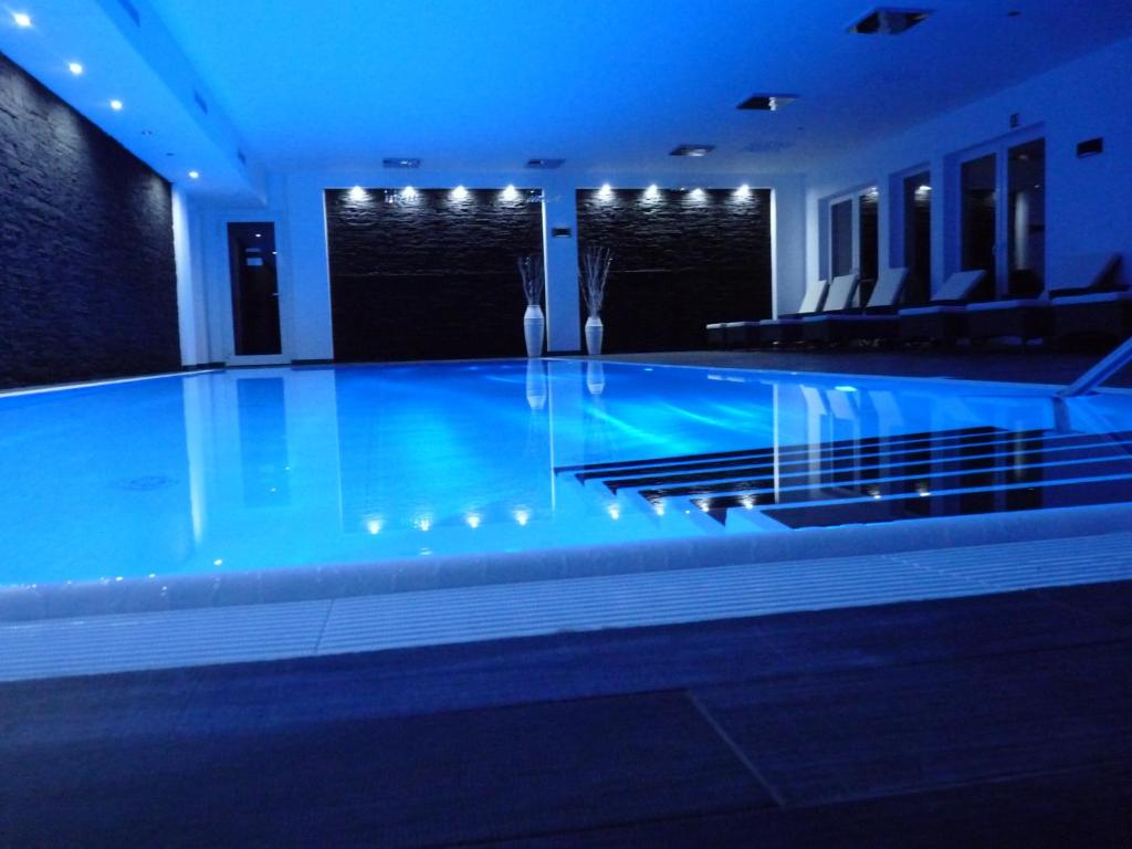 Neu Zauche的住宿－Spreewaldhof Romantik - Hotel Garni，蓝色灯光的建筑中的游泳池