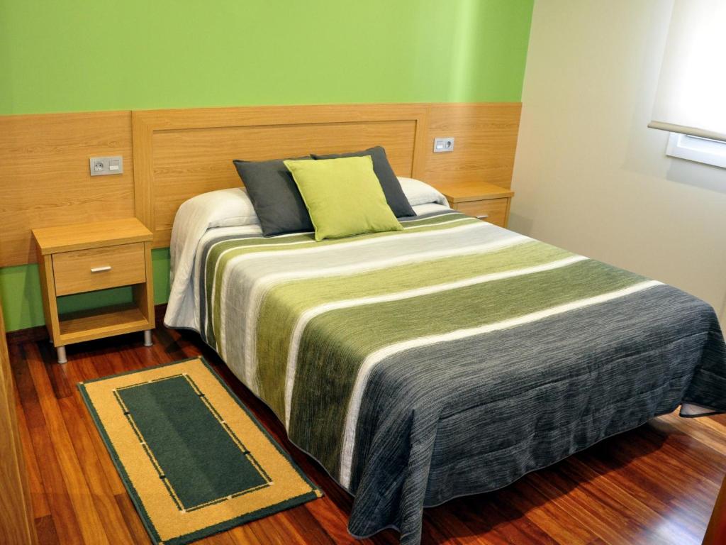 a bedroom with a large bed with a green wall at Hostal Paz in Gondomar