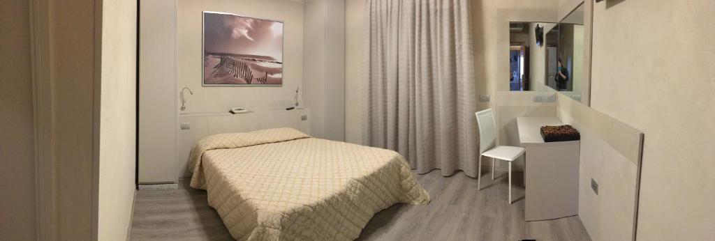 Habitación blanca pequeña con cama y baño. en Hotel da Filie', en Querceta
