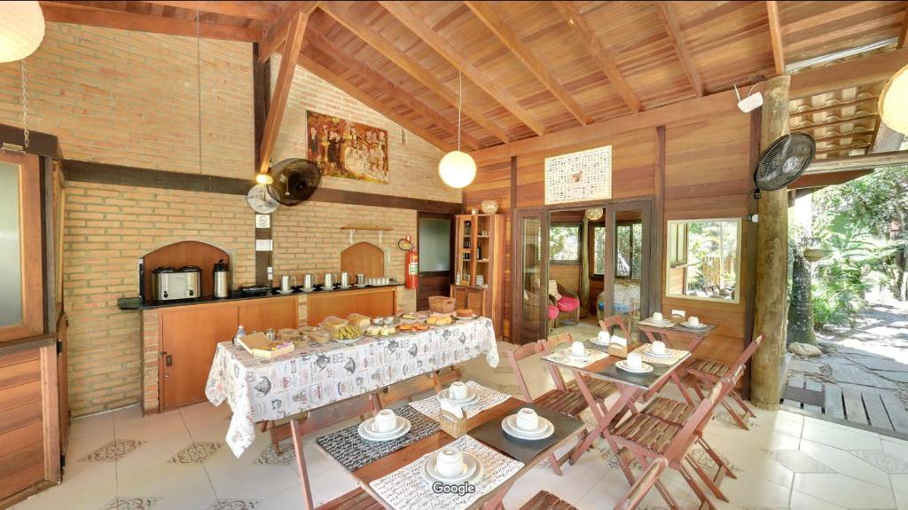 uma cozinha e sala de jantar com mesa e cadeiras em Pousadinha na Ilha do Mel
