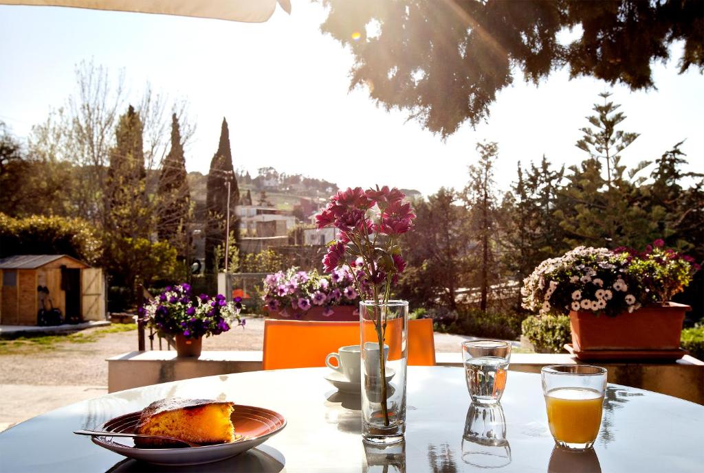 una mesa con un plato de comida y un vaso de zumo de naranja en Hotel Terra degli Elimi, en Buseto Palizzolo