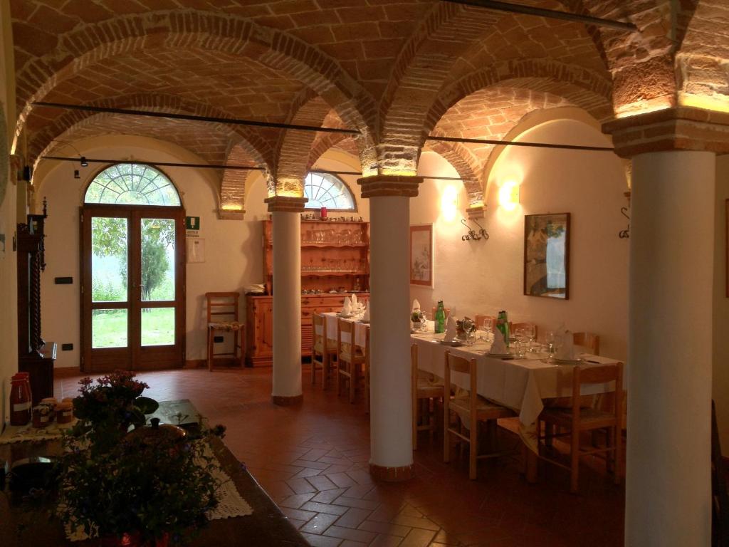 une salle à manger avec des tables et des chaises dans un bâtiment dans l'établissement Monte Bibele, à Monterenzio