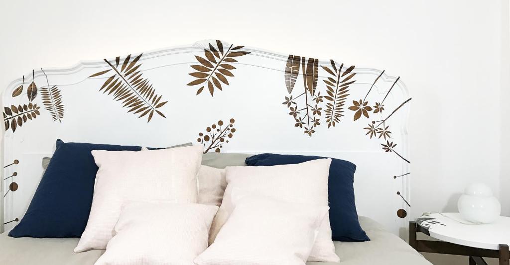 Una cama con almohadas blancas y plantas. en Castagna Amara, en Montevecchia