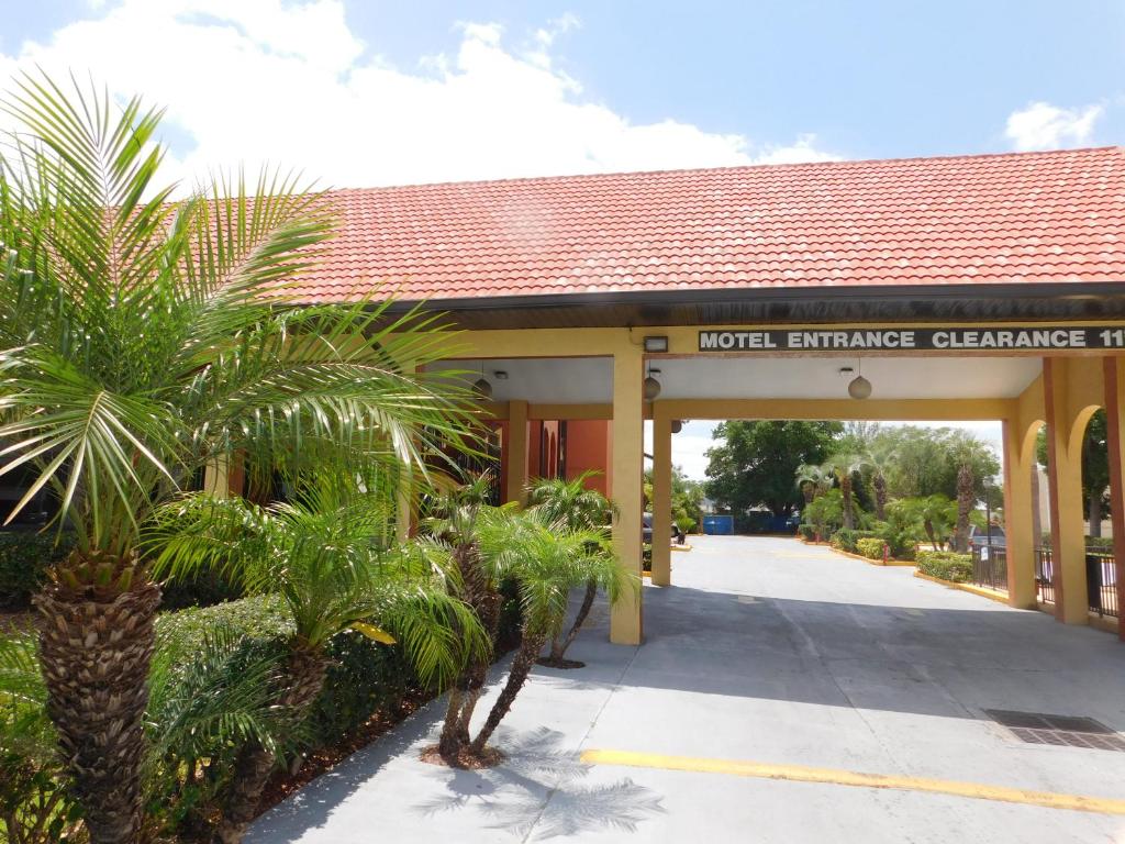 a hotel entrance with palm trees and a building at Budget Inn Of Orlando in Orlando