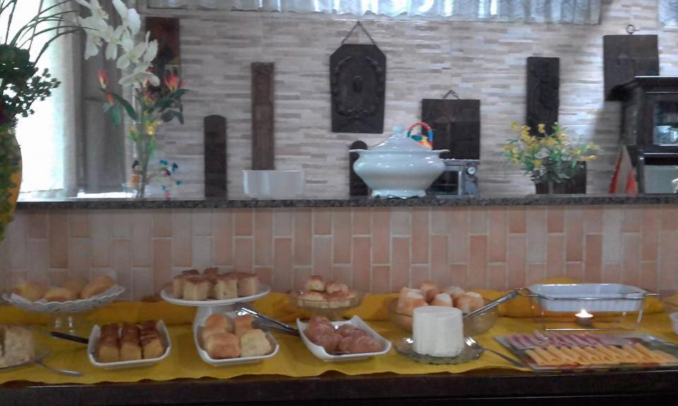 een buffet met brood en andere gerechten op tafel bij Pousada Luar e Serenata in Conservatória