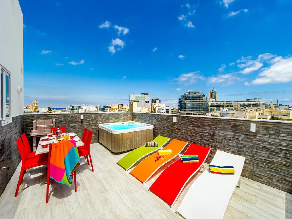 d'un balcon avec une table, des chaises et une piscine. dans l'établissement Bayside Apartments, à San Ġiljan