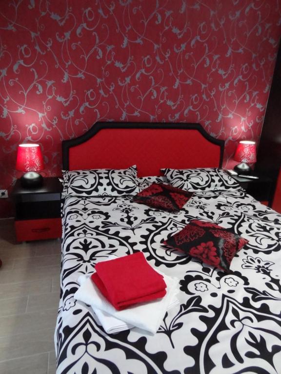 ママイアにあるFelicia Residenceのベッドルーム(赤い枕の黒と白のベッド付)