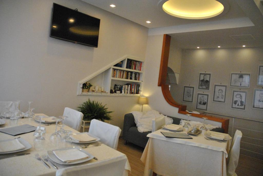 a dining room with white tables and white chairs at Hotel Villa Fiorita in Sorrento