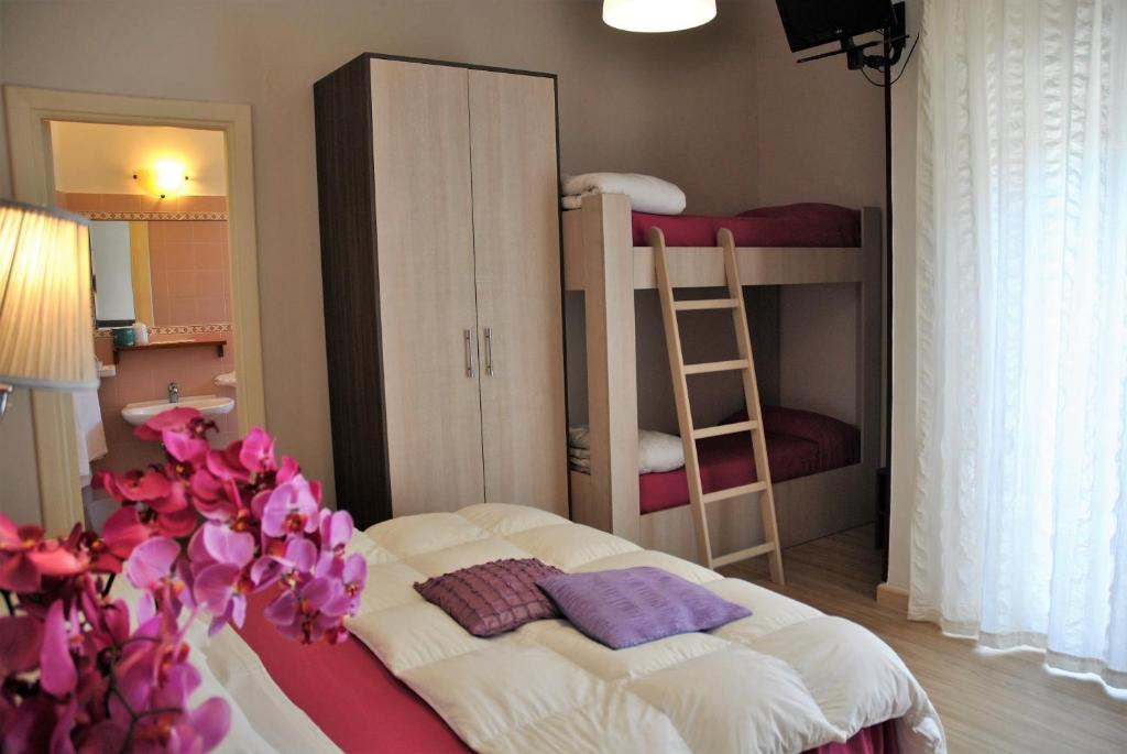 a bedroom with two bunk beds and a bed with purple pillows at Hotel Villa Fiorita in Sorrento