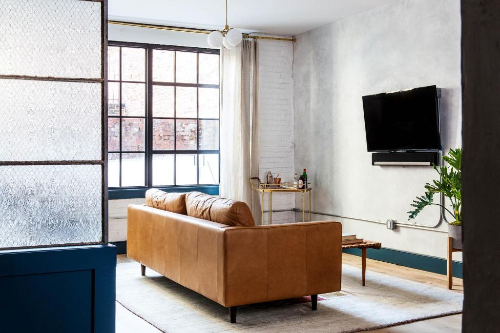 a living room with a couch and a tv at Lokal Hotel Old City in Philadelphia