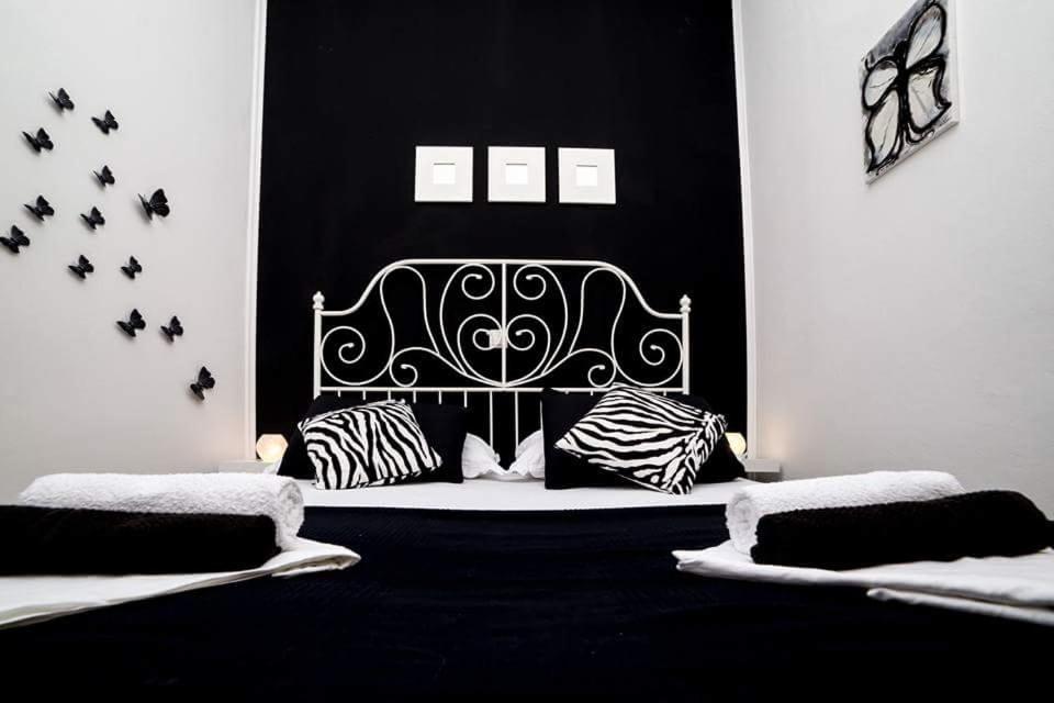 a black and white bedroom with a bed with black and white pillows at Apartments Zara in Petrcane