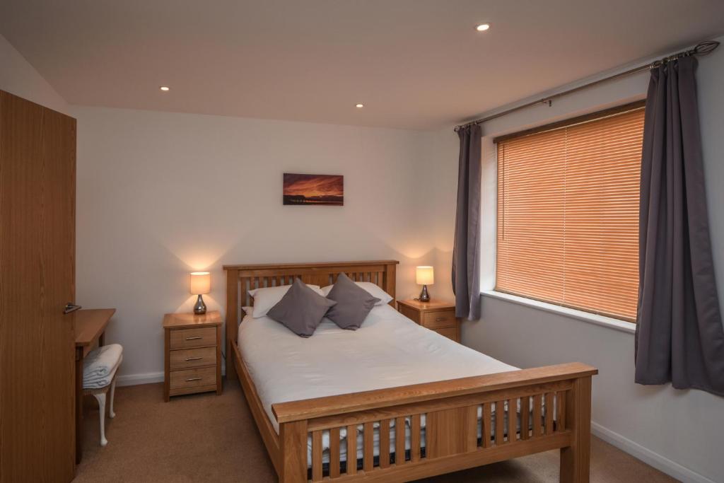 een slaapkamer met een groot bed en een raam bij Parc y Bryn Serviced Apartments in Aberystwyth