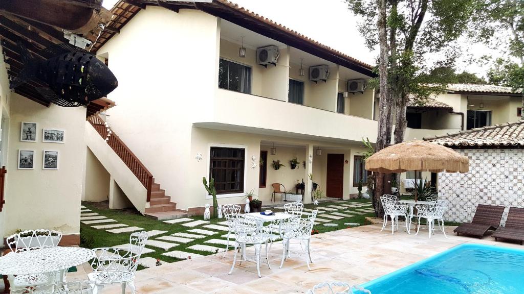 a patio with tables and chairs next to a house at Pousada Maria Bonita in Arraial d'Ajuda