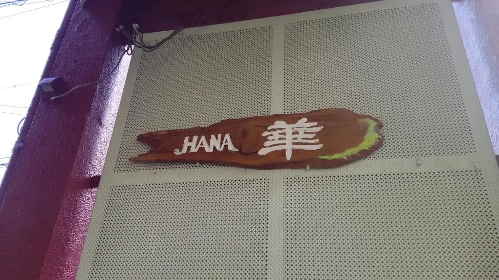 una señal en una pared con una señal de karma en ella en Guest House Hana, en Otsu