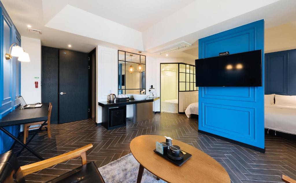 a hotel room with a blue door and a bedroom at Boutique Hotel XYM Pyeongtaek in Pyeongtaek