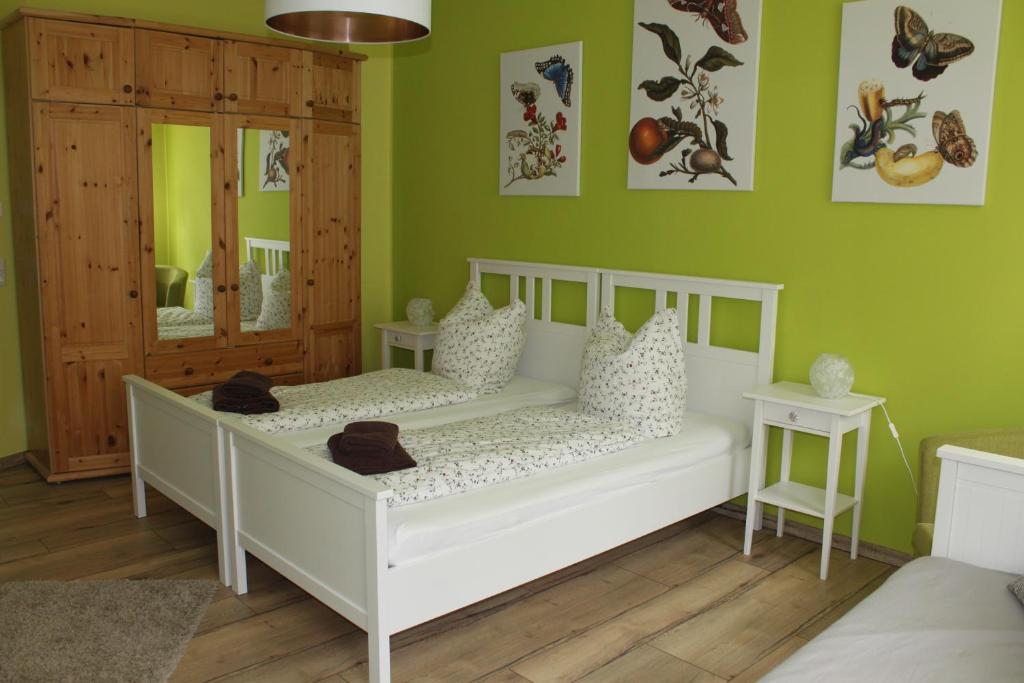 ライプツィヒにあるFerienwohnung Hechtの緑の壁のベッドルーム1室(白いベッド1台付)