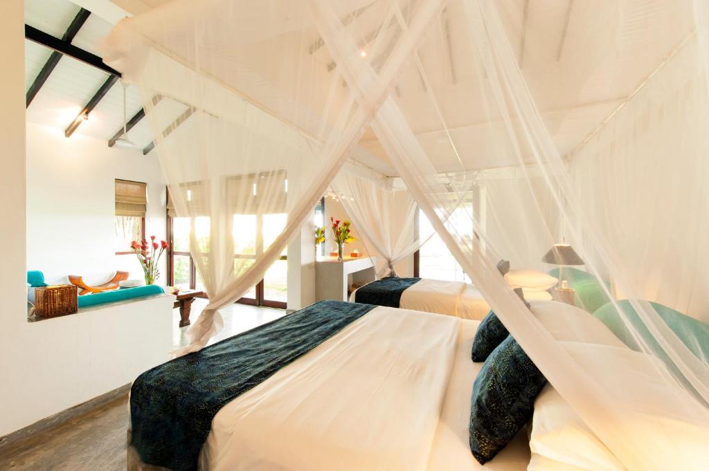 a bedroom with two beds and a living room at Apa Villa Thalpe in Unawatuna