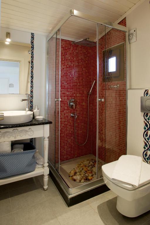 a bathroom with a shower with a toilet and a sink at Lodos Butik Hotel in Alaçatı
