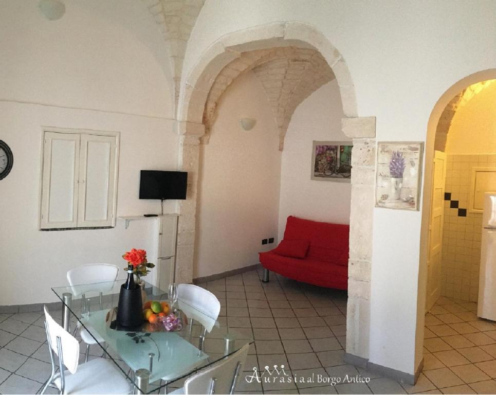 オストゥーニにあるAurasia Al Borgo Anticoのリビングルーム(赤いソファ、ガラステーブル付)