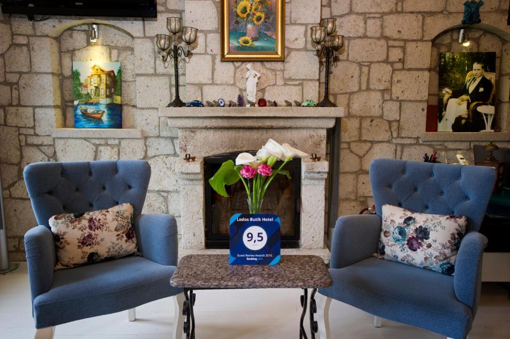 two blue chairs in a living room with a fireplace at Lodos Butik Hotel in Alaçatı