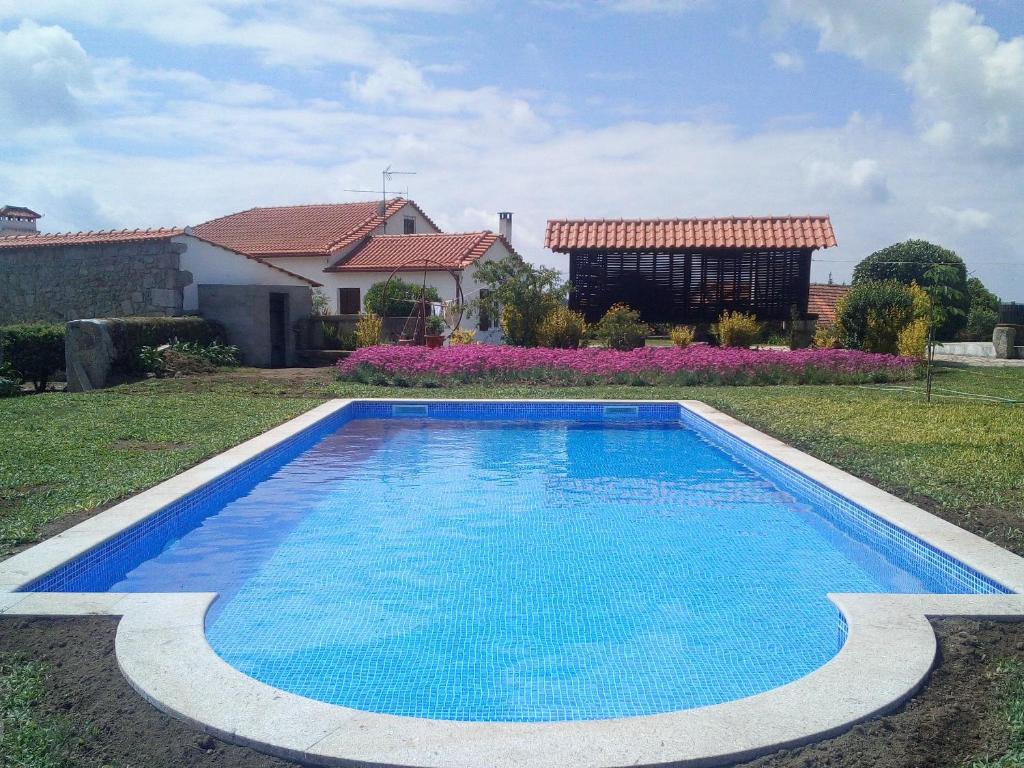 a swimming pool in the yard of a house at Casa do Souto in Aldreu