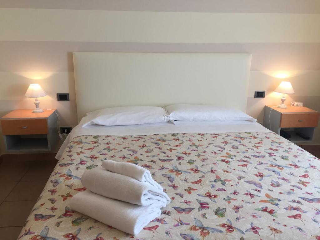 a bedroom with a large bed with towels on it at Hotel Eden in Bardolino
