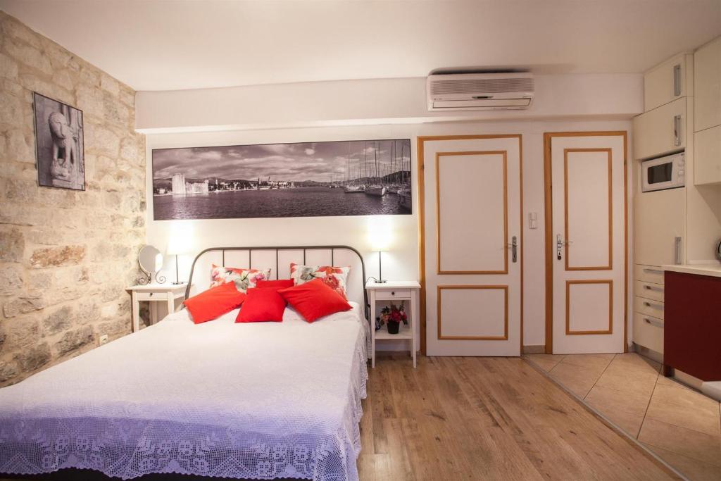 トロギールにあるApartment & Room Ursaのベッドルーム1室(赤い枕のベッド1台付)