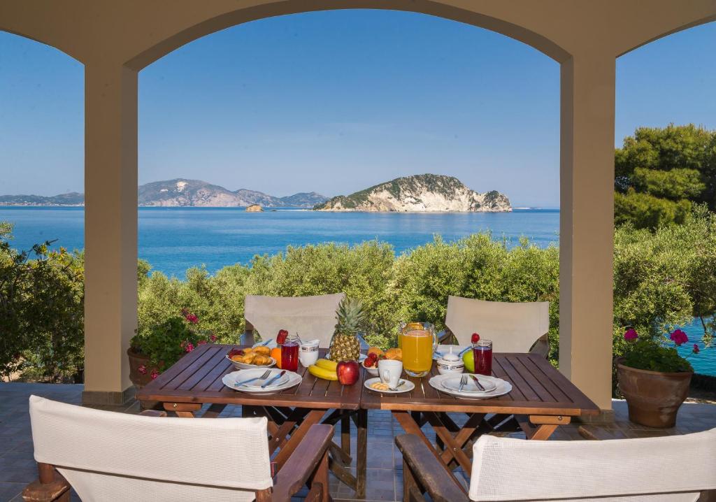 una mesa y sillas en un patio con vistas al océano en Arba Rooms, en Marathias