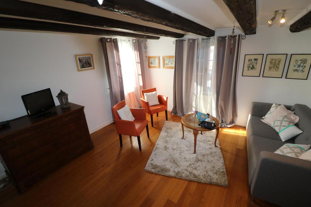 a living room with a couch and a table and chairs at Appartement Bastion de Riquewihr in Riquewihr