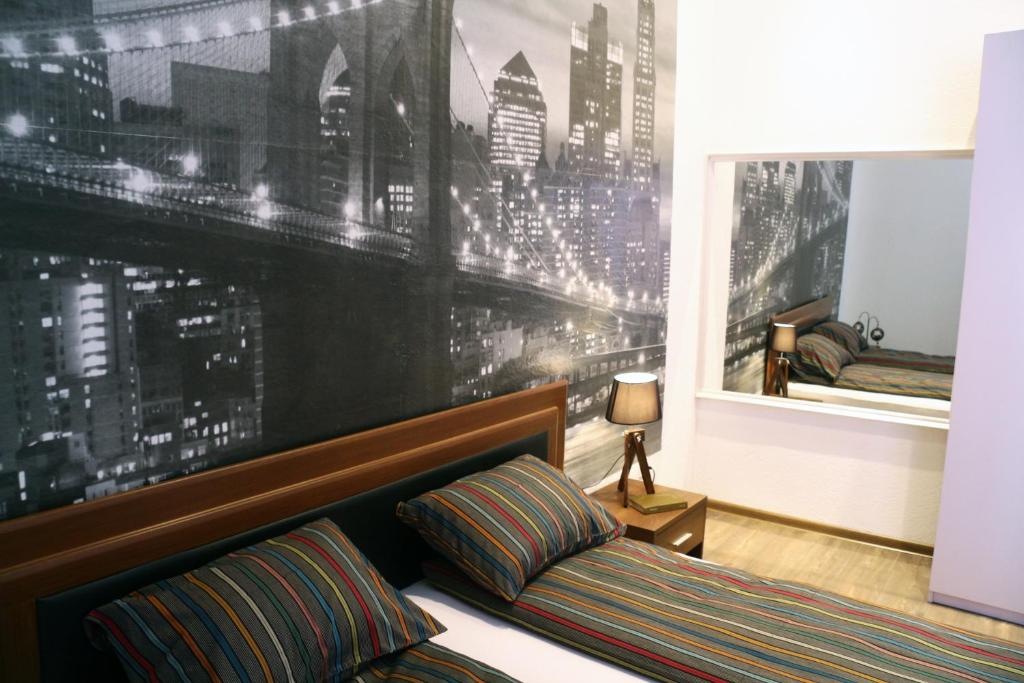 a bedroom with a large mural of a city at Apartment Sarajevo Center in Sarajevo
