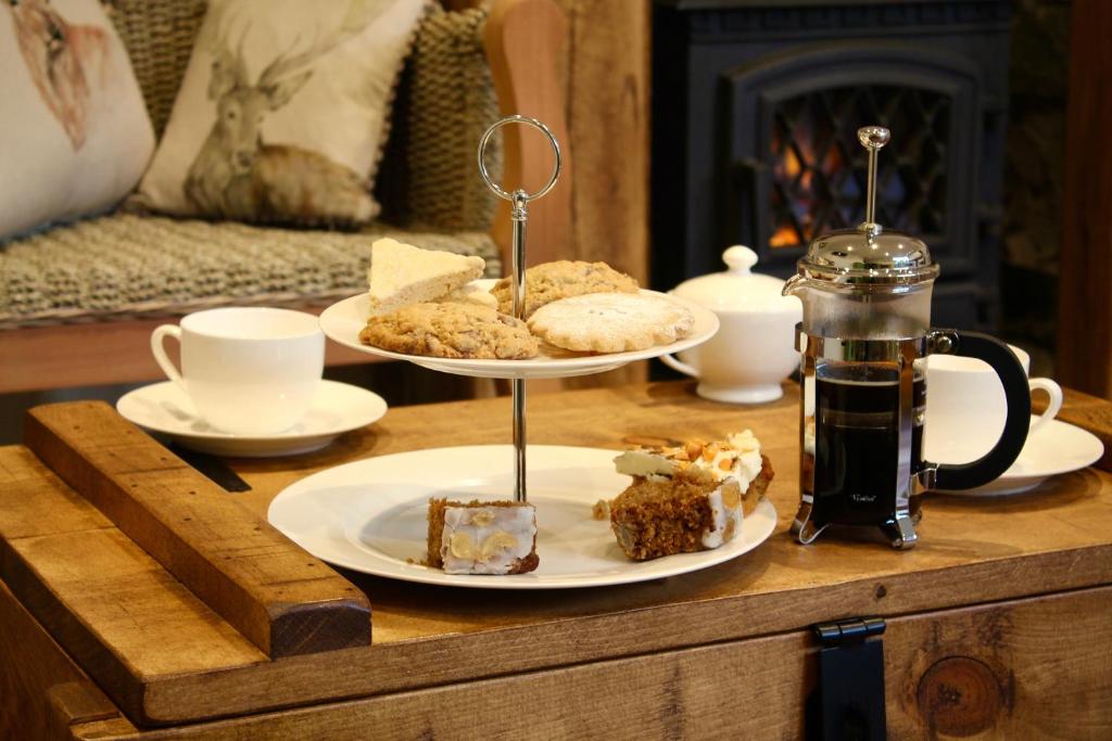 een tafel met twee borden gebak en koffie erop bij The Barn in Monk Fryston