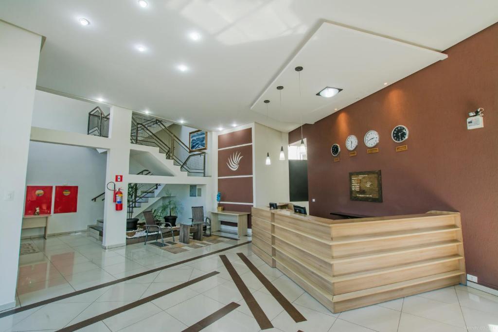 a lobby of a building with a staircase at Hotel Dom Thomaz in Jaguariaíva