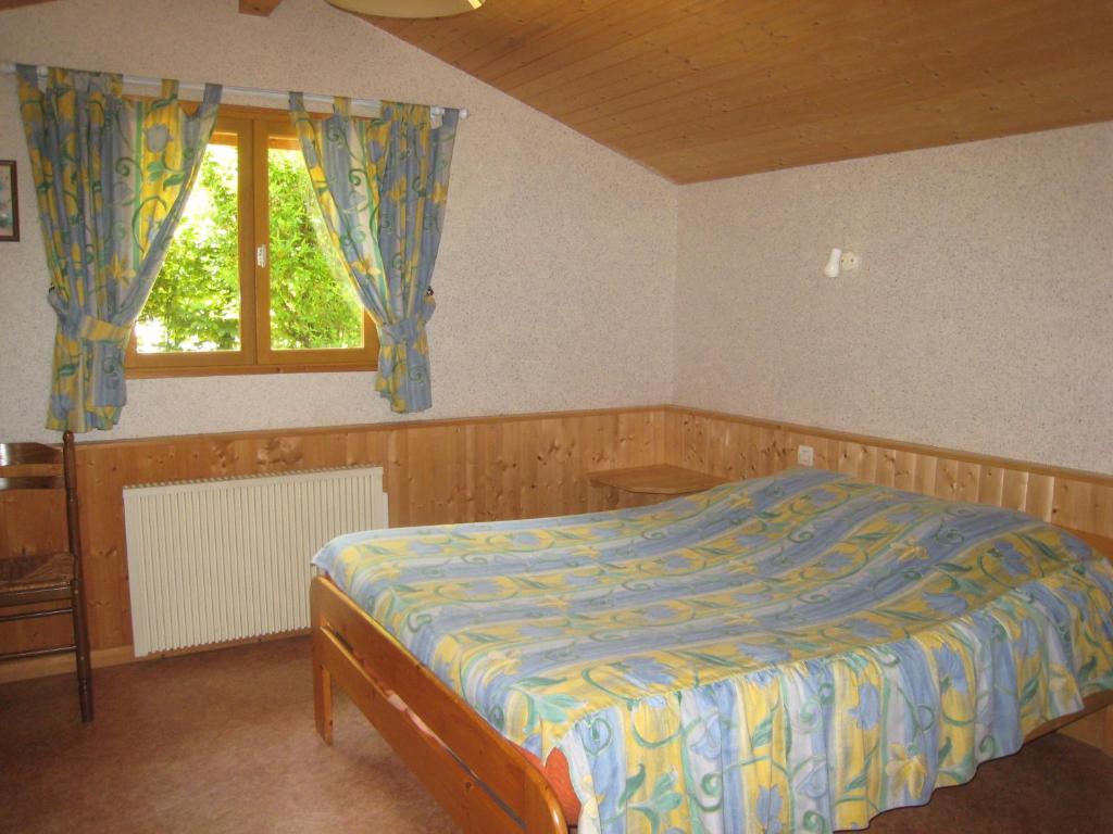 1 dormitorio con cama y ventana en Le bois ramé, en Neuvecelle